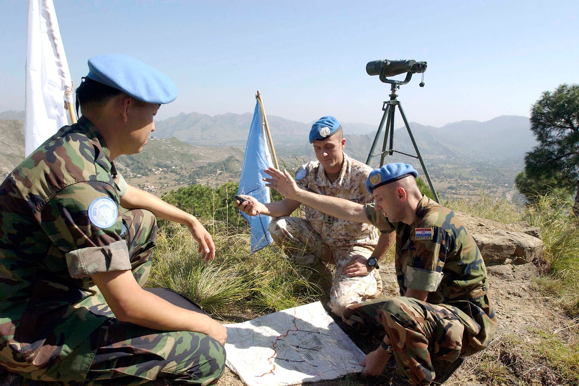 Peacekeepers from the UN Military Observer Group in India and Pakistan (UNMOGIP) are pictured here, near Pakistan’s Bhimbar field station in October 2005, going over their plans for the day in observing the Line of Control that separates the two countries. UN Photo/Evan Schneider