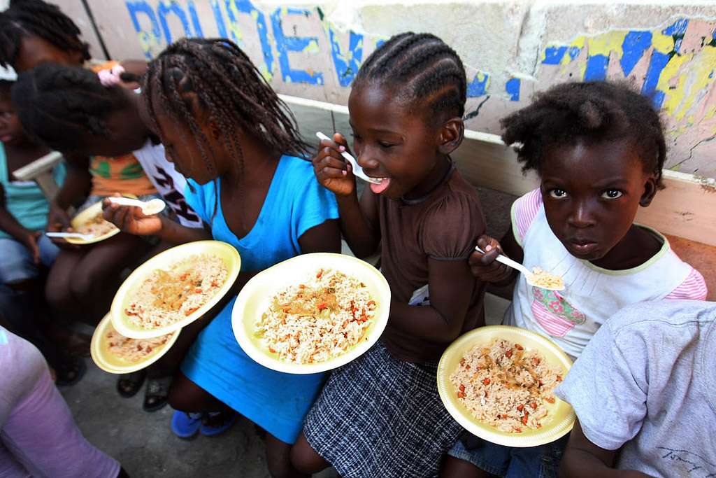 In Haiti, children in Port-au-Prince slum of Bel Air enjoying a meal. Photo: MINUSTAH