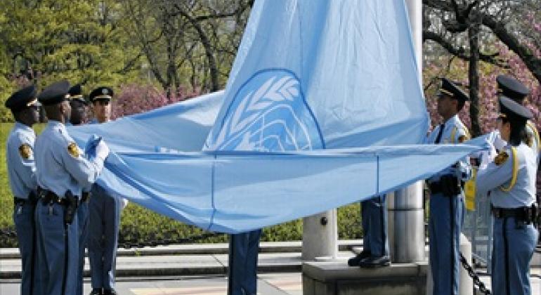 United Nations security officers raise the UN flag.