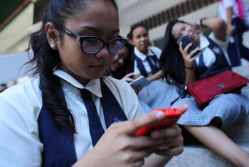 A student at St. Francis of Assisi School and other girls, check their smart phones after classes in the Central Visayas city of Cebu, Philippines.