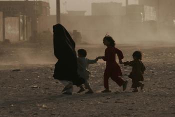 A family struggles through a dusty environment in Afghanistan. Photo