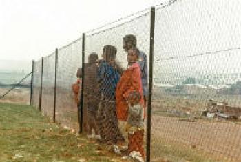 Children behind fence that separates them from the white community near Johannesburg, during the time of apartheid in South Africa.