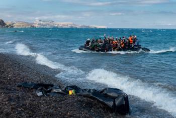 Newly arriving refugees wave and laugh as the large inflatable boat they are in approaches the shore, near the village of Skala Eressos, on the island of Lesbos, in the North Aegean region of Greece.