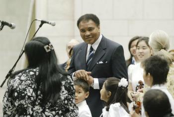 Muhammad Ali (centre), UN Messenger of Peace and former three-time World Heavyweight Champion boxer, at a 2004 ceremony to mark the International Day of Peace at UN Headquarters.