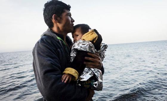 Un refugiado de Afganistán sostiene a su hijo pequeño tras arribar a las costas de la isla de Lesbos en Grecia. Ambos cruzaron el mar Egeo desde Turquía en una balsa inflable repleta de más refugiados Afganos. Foto: ACNUR/Achilleas Zavallis