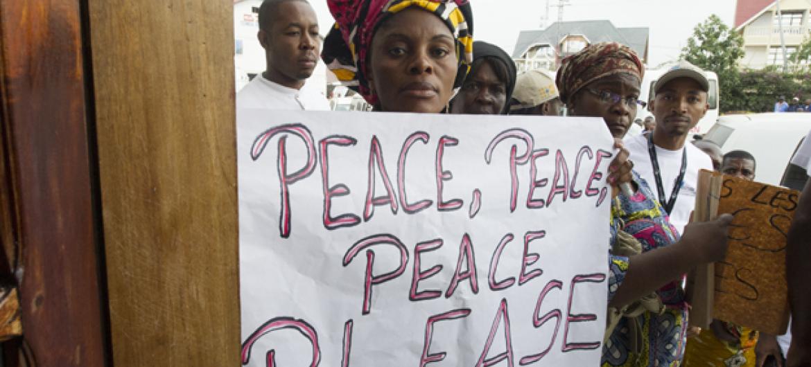 Mulher carrega cartaz com mensagem de paz na República Democrática do Congo. Foto: ONU/Eskinder Debebe