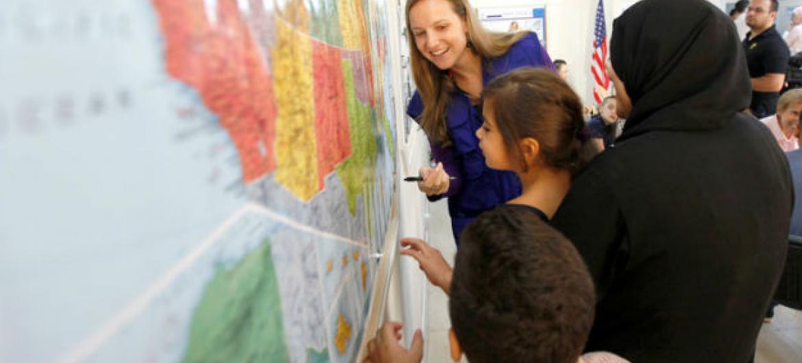 Jovens refugiados sírios estudam mapa dos Estados Unidos. Foto: Victoria Hazou/OIM