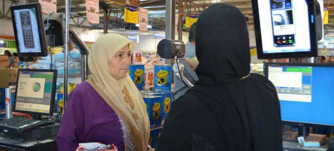 Hana Heraaki, refugiada síria, compra comida com o projeto de registo biométrico. Foto: PMA/Shada Moghraby