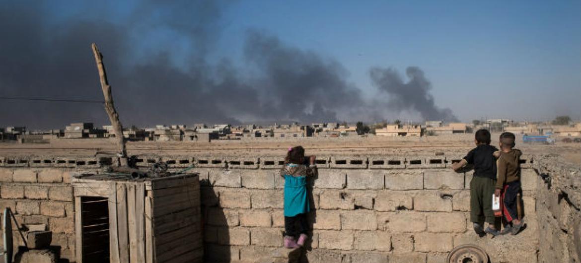 No topo de suas casas, srianças olham fumaça de poços de petróleo incendiados por integrantes do grupo terrorista Isil quando deixaram a cidade de Qayyarah, no sul de Mossul (arquivo). Foto: Unicef/Mackenzie