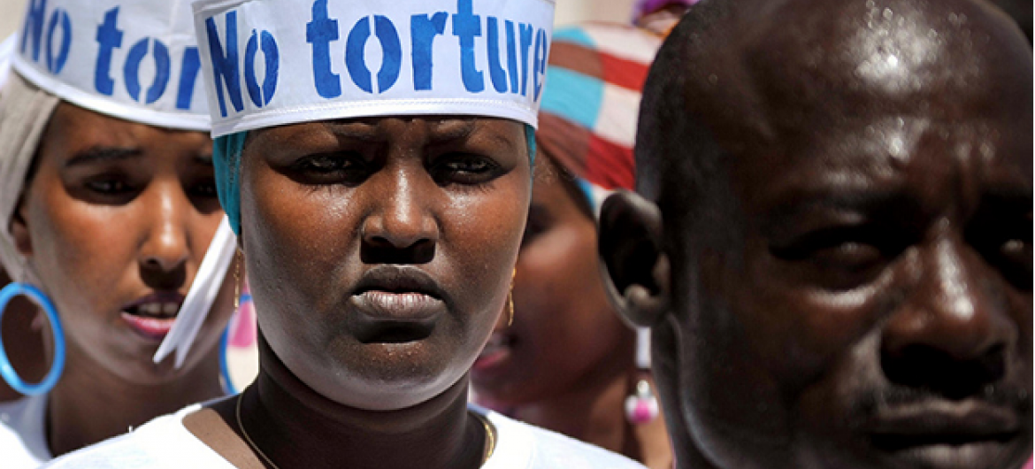 Somalis com chapéus com inscrição "Não à tortura" em evento do Dia dos Direitos Humanos no exterior da Cadeia Central de Mogadíscio. Foto: ONU/ Tobin Jones.