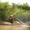 Mulher à pesca num rio no Camboja. Foto: FAO