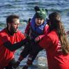 Voluntários ajudam criança a sair do barco em Lesbos, Grécia. Foto: Acnur/Achilleas Zavallis