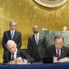 Ban Ki-moon (à dir.) e o chefe da OIM, William Lacy Swing, assinam o acordo entre ONU em OIM. Foto: ONU/Rick Bajornas