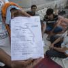 Migrantes paquistaneses em Kos, na Grécia, mostram um mapa que eles receberam com informações sobre o fechamento da fronteira da Hungria. Foto: OIM