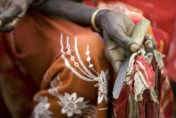 Em encontro comunitário na vila de Kabele, na Etiópia, ex-praticande de mutilação genital feminina segura a ferramenta utilizada por ela para realizar o procedimento. Foto: Unicef/UNI77840/Holt