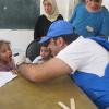 Daktari UNRWA anachunguza mtoto huko Yalda, Damascus, Syria, katika harakati za kudhibiti ugonjwa wa homa ya maumbo. Picha: UNRWA
