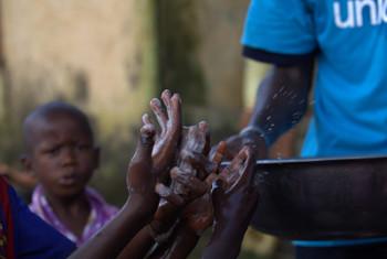 Muhamasishaji akiwafundisha watoto kuhusu mbinu sahihi za unawaji mikono, ili kuzuia kuenea kwa magonjwa, ikiwa ni pamoja na Ebola. Picha: UNICEF / Timothy La Rose